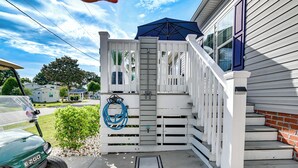 A gated entrance with a blue umbrella, a white picket fence, and a small garden area. - Resort Home ~ 1 Mi to Myrtle Beach Access! (Myrtle Beach)