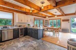 Enjoy meals in the spacious kitchen with a large island, sink, and ample counter space, surrounded by dining area with a table and chairs.