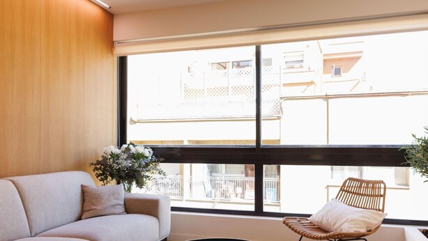 A modern living room with a sofa, a round coffee table, and a wicker chair. - Bravissimo Centre, Modern 2-bedroom apartment (Girona)