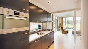 A modern kitchen with stainless steel appliances, a large window, and a view of the outdoors. - 2 bedroom lovely home in Zorgvlied (Zorgvlied)