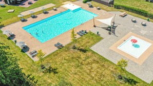 An aerial view of a residential property with a large rectangular swimming pool, outdoor seating areas, and a small garden. - 2 bedroom lovely home in Zorgvlied (Zorgvlied)