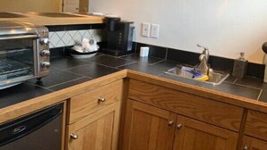 A compact kitchen with a toaster, coffee maker, and sink. - Spacious Guest Suite! Close to Airport! Quiet Area (Calgary)
