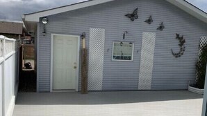 A single-story building with a flat roof, a white door, and a small window. - Spacious Guest Suite! Close to Airport! Quiet Area (Calgary)