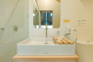 A bathroom with a white sink, mirror, and a towel rack. - Bobocabin Gunung Mas (Cisarua)