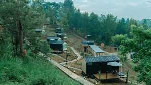 A hillside residential area with multiple modern houses, each featuring a distinct architectural style. - Bobocabin Gunung Mas (Cisarua)