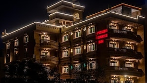 A multi-story hotel with balconies, illuminated signage, and a prominent rooftop structure. - Pyramids Sunrise Inn (Giza)