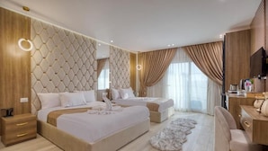 A modern hotel room with a large bed, a smaller bed, a desk, and a television. - Pyramids Sunrise Inn (Giza)