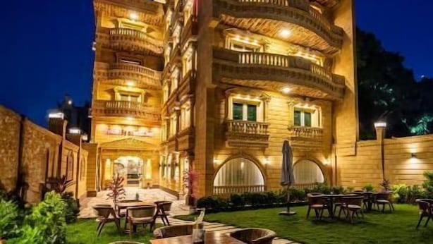 A multi-story hotel with outdoor seating and a well-lit facade. - Pyramids Sunrise Inn (Giza)