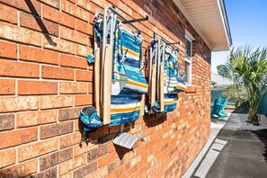 A brick building with a metal rack holding striped towels.