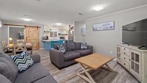 Een moderne woonkamer met een bank, salontafel en tv-meubel.