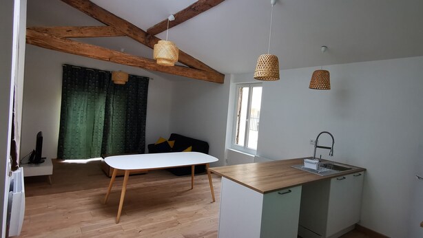 Una cocina compacta con encimera de madera, un lavamanos integrado y un refrigerador pequeño.