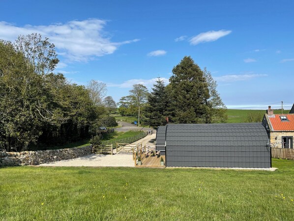 A rural setting with a stone wall, a wooden fence, and a house with a dark roof. - Wood View - UK43707 (Scarborough)