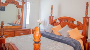 A bedroom with a wooden four-poster bed, a dresser, and a mirror. - Puerto Plata House Full of Peace ❤️ (puerto plata)