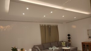 Ein modernes Wohnzimmer mit einer Couch, einem Esstisch und einem kleinen Beistelltisch.