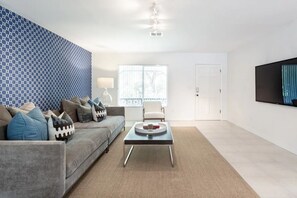 Relax in this stylish living room with a sofa, coffee table, and armchair, perfect for unwinding in comfort.