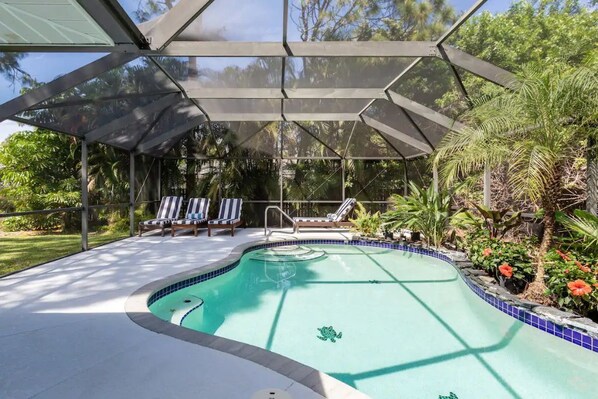 Relax by the pool surrounded by lush greenery and a unique turtle design.