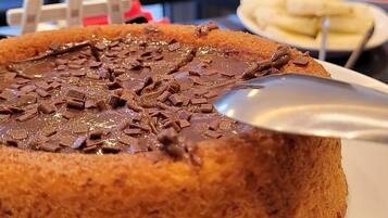A dessert with chocolate chunks on a plate, with a blurred background of a restaurant setting.