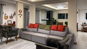 A modern living room with a grey sofa, a black armchair, and a patterned rug.