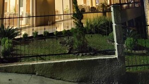 A multi-story building with illuminated windows and a gated entrance.