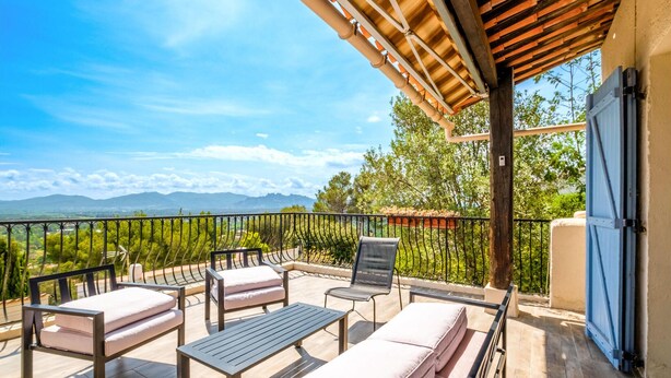 Un balcon doté de mobilier d’extérieur, d’une pergola et offrant une vue sur les montagnes.