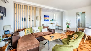 Un salon moderne avec un canapé d’angle, une table basse et un coin repas comprenant une petite table et des chaises.