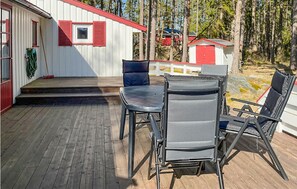 Enjoy dining or socializing on the cabin's outdoor deck, surrounded by a serene forest.