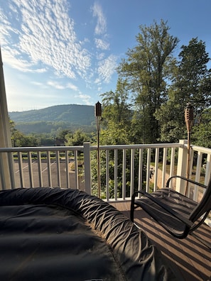 A balcony with a view of a parking lot and hills, a lamp post, and a chair. - Beautiful New Townhome with Mountain Views. Close to downtown! (Charlottesville)