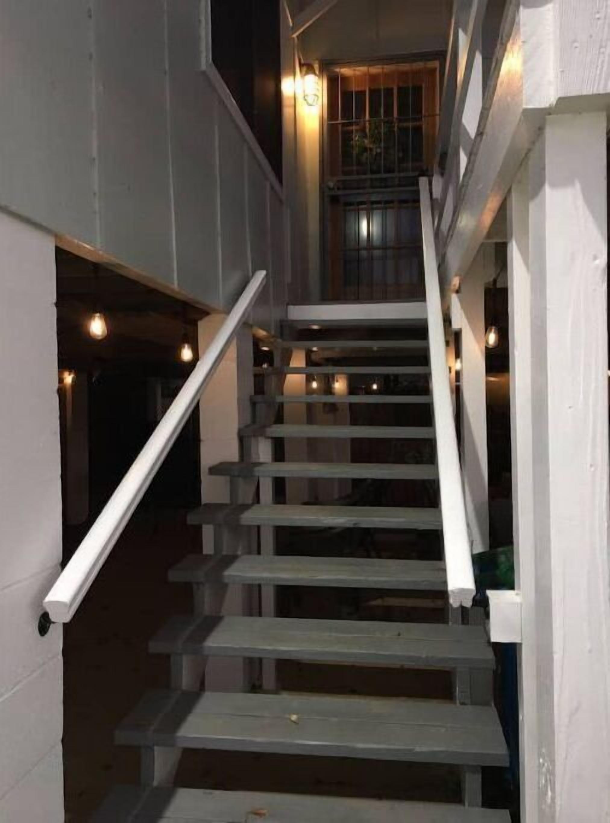 A staircase with white railings and wooden steps leading to an upper level.