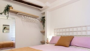 A bedroom with a bed, a bedside table, a hanging plant, and a mirror. - El Rincón de Cañadío · Charming Apartment in the Heart of Santander (Santander)