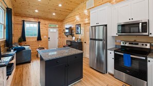 Une cuisine moderne avec des murs en bois, des appareils électroménagers en acier inoxydable et un plan de travail en granit.