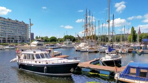 Een jachthaven met diverse boten afgemeerd, waaronder zeilboten en motorboten.