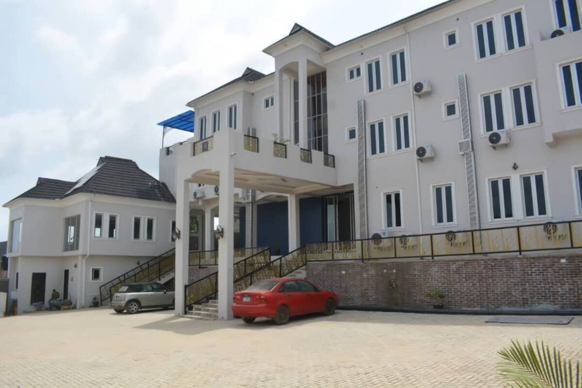 A multi-story residential building with a covered entrance and a car parked in front.