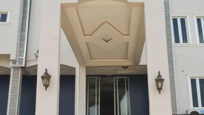 A multi-story residential building with a central staircase, a balcony with decorative railings, and a car parked in the driveway. - Camas Hotel & Suite Asero Abeokuta (Abeokuta)