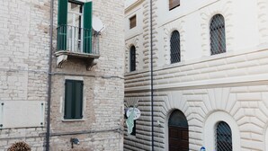 A building with a balcony, a satellite dish, and a sign indicating a hotel.