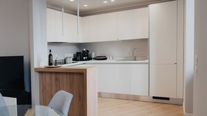 A modern kitchen with white cabinets, a wooden countertop, and a built-in sink.