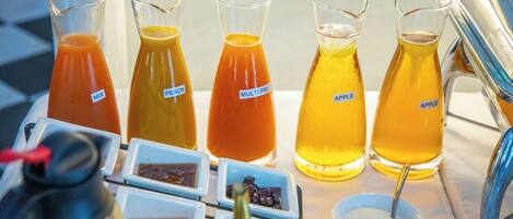 A table with various beverages and condiments, including labeled pitchers and small bowls.