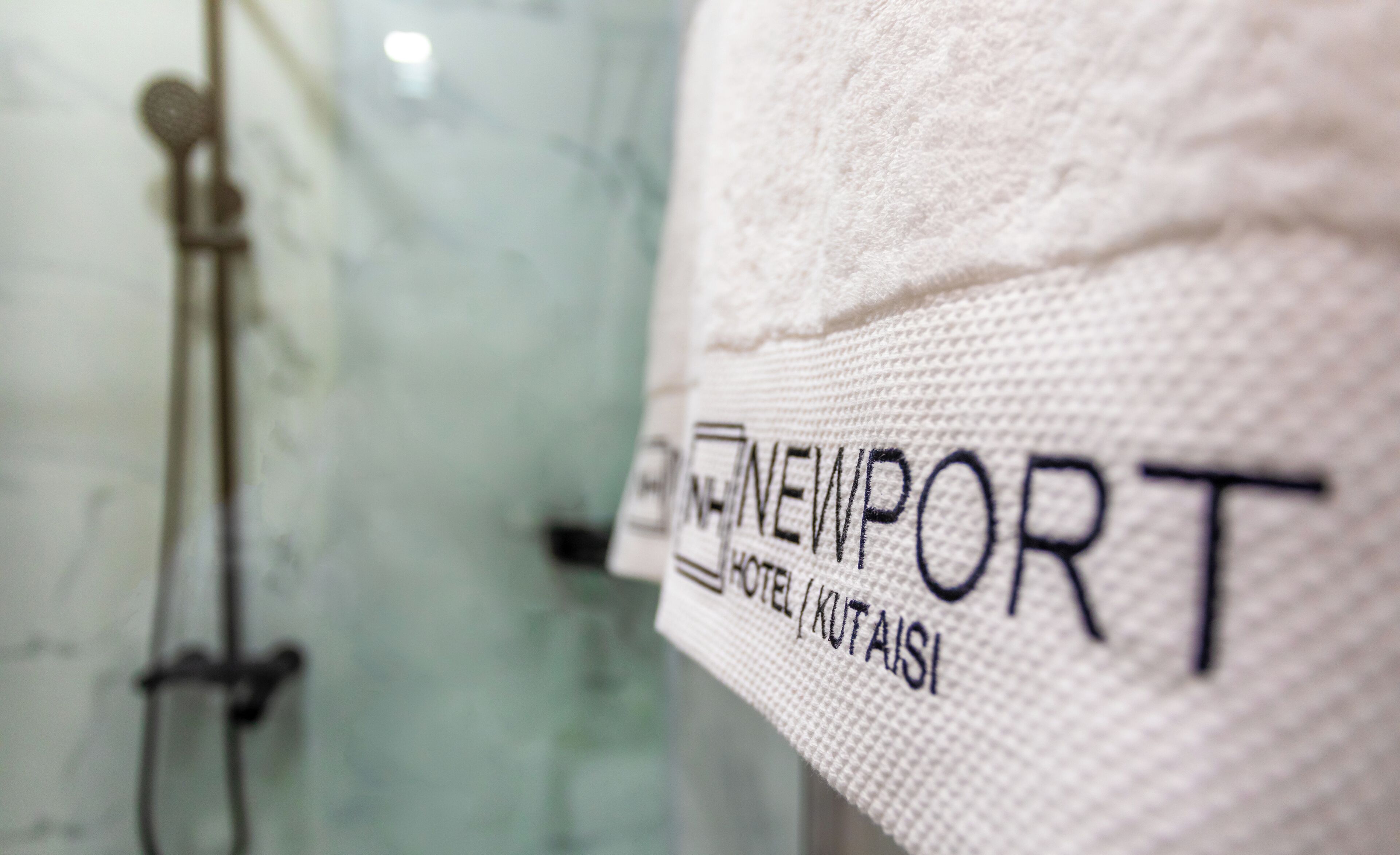 A close-up of a towel with the text "NEWPORT HOTEL" and "KUTAIS" on it.