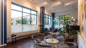 Una habitación amplia con ventanas grandes, una mesa redonda y varias sillas.