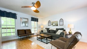 A living room with a ceiling fan, a sofa, a coffee table, and two lamps. - Lake Front, Sunrise, Dock, Kayaks + Game Room (Cadiz)