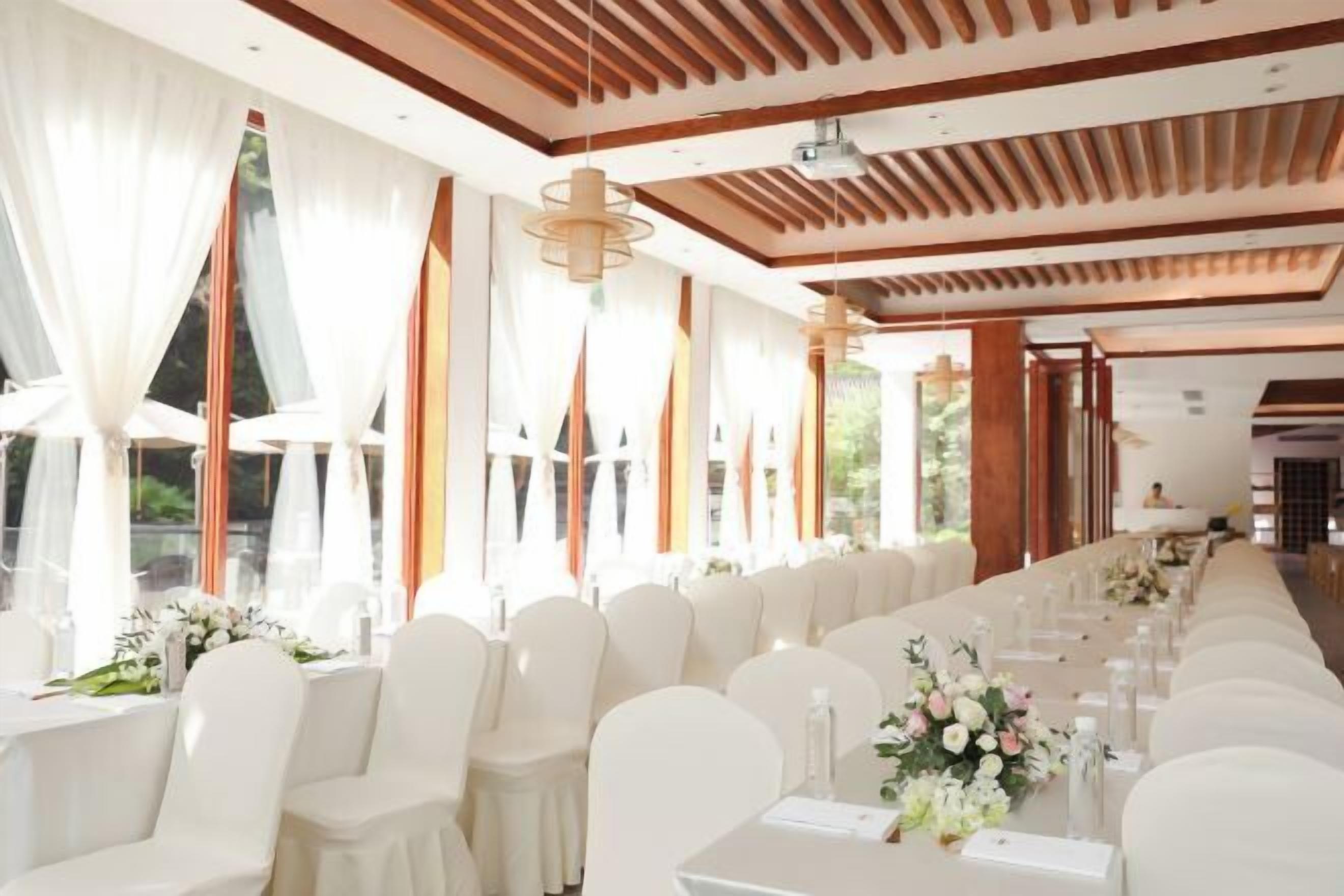 A long banquet table with white chairs, set for a formal event.