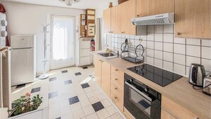A compact kitchen with a built-in oven, a sink, and a stove.