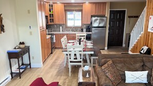 A living room with a brown leather couch, a red throw blanket, and a 'GATHER' pillow. - Escape to the Pocono Mountains. (Tannersville)