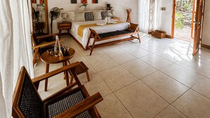 Una habitación con cama, escritorio, silla, ventilador y ventana.