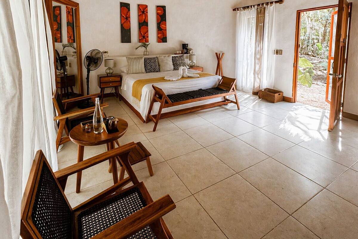 A room with a bed, a desk, a chair, a fan, and a window.