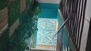 A staircase with a wooden railing and a wall covered in green foliage. - Hotel Avadia Del Mar (Cartagena)