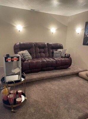 Relax in this inviting living room with a sofa, patterned cushions, and a home theater setup.