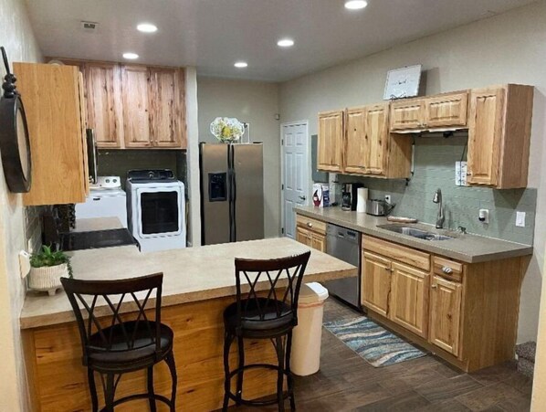 Enjoy cooking in this well-equipped kitchen with a central island, bar stools, and modern appliances.