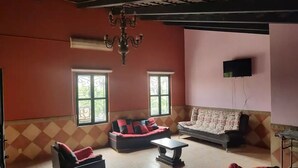 A living room with two sofas, a coffee table, and a TV mounted on the wall.