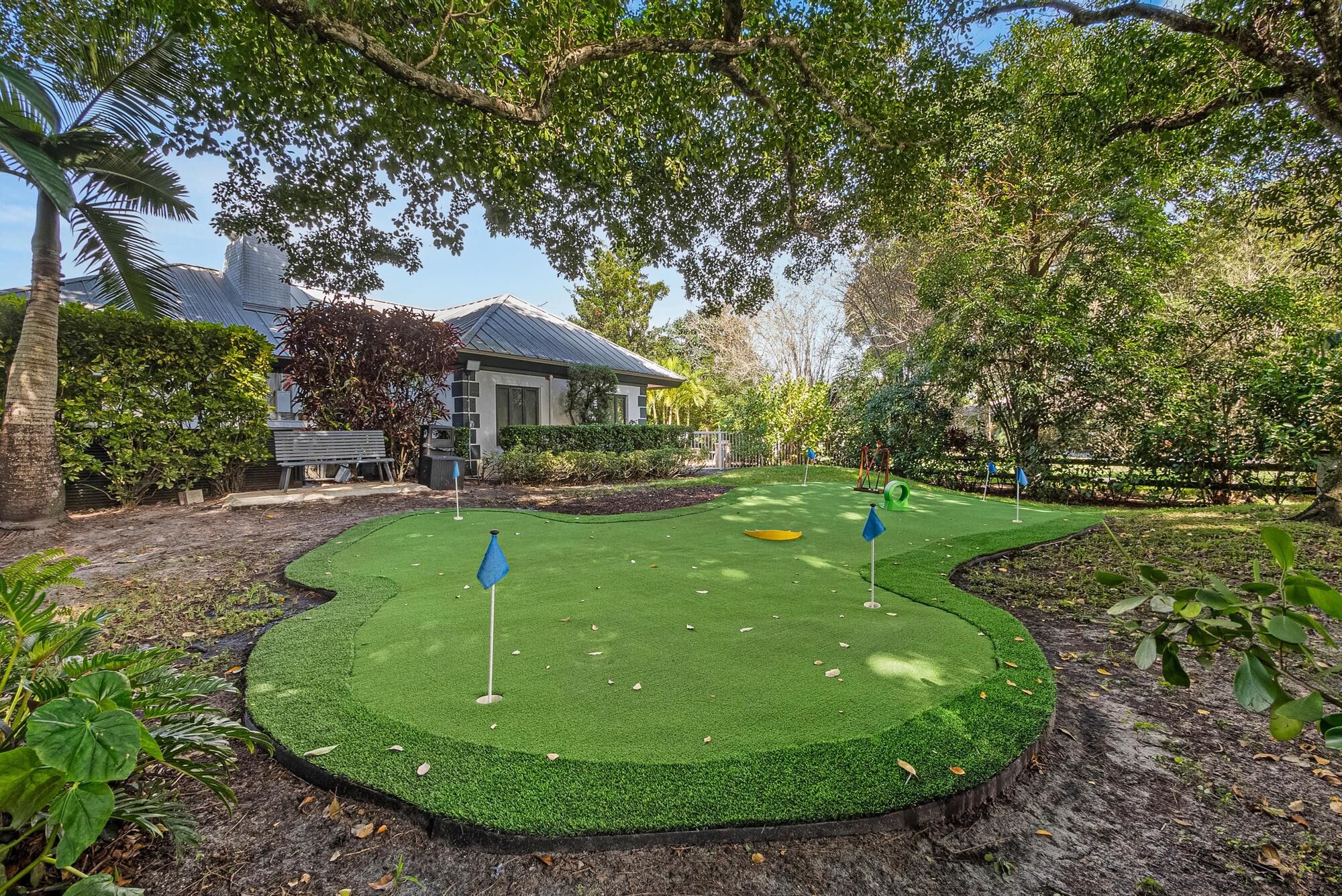 A miniature golf course with a house in the background.