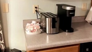 En köksbänk med en kaffebryggare och en brödrost.